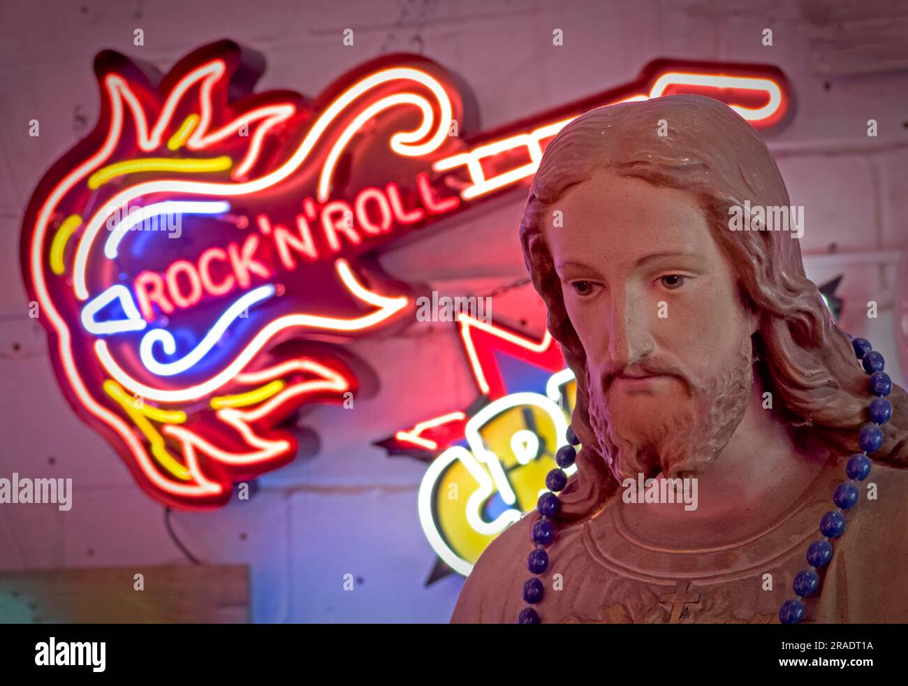 Jesus-Statue, Kumpel Christus, mit Neonlicht-Design - Rock and Roll-Gitarre Stockfoto