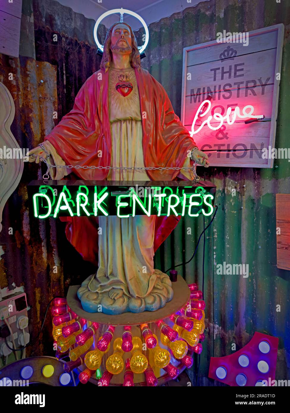 Jesus Statue Buddy Christ, mit Neonlicht-Design - das Ministerium für Liebe und Action, dunkle Einträge Stockfoto
