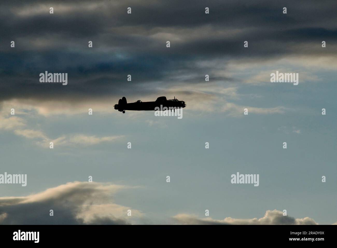 Flug im Battle of Britain Memorial, Lancaster-Flugzeug, über humberside, Großbritannien, Silhouette gegen dunkle Wolken Stockfoto