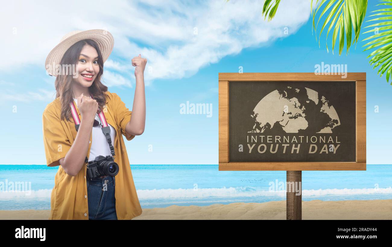 Frau mit Hut und Kamera mit internationaler Jugendtagsmeldung. Konzept für den Internationalen Jugendtag Stockfoto