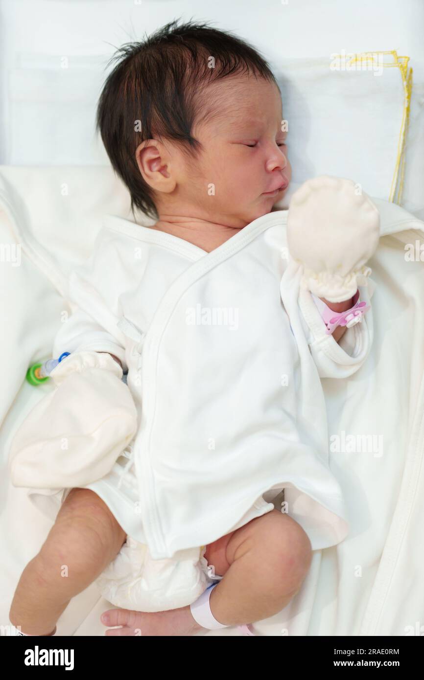 Neugeborene, die im Säuglingskorb im Krankenhaus liegen und schlafen Stockfoto