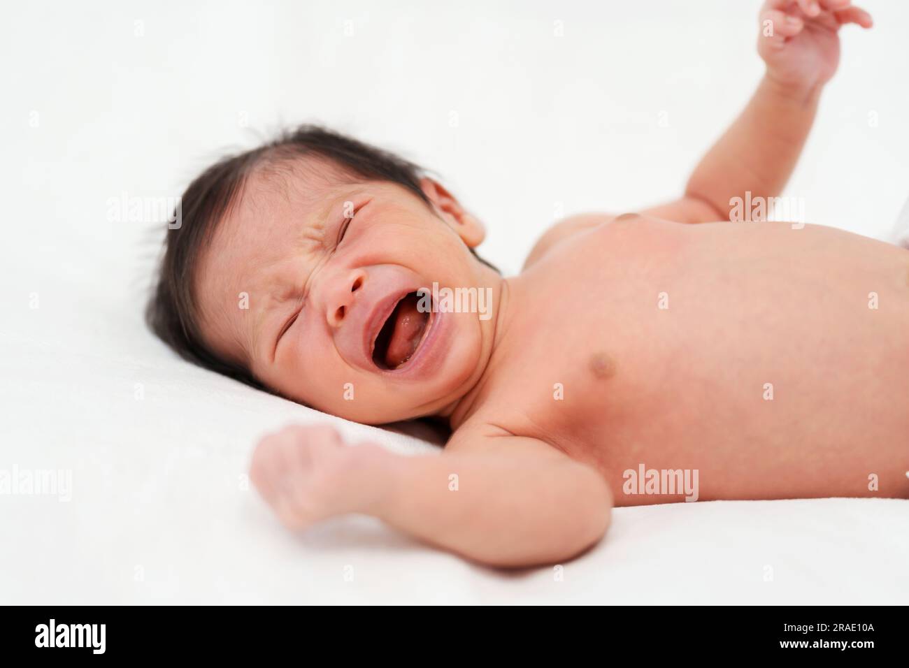 Neugeborenes weint auf einem Bett Stockfoto