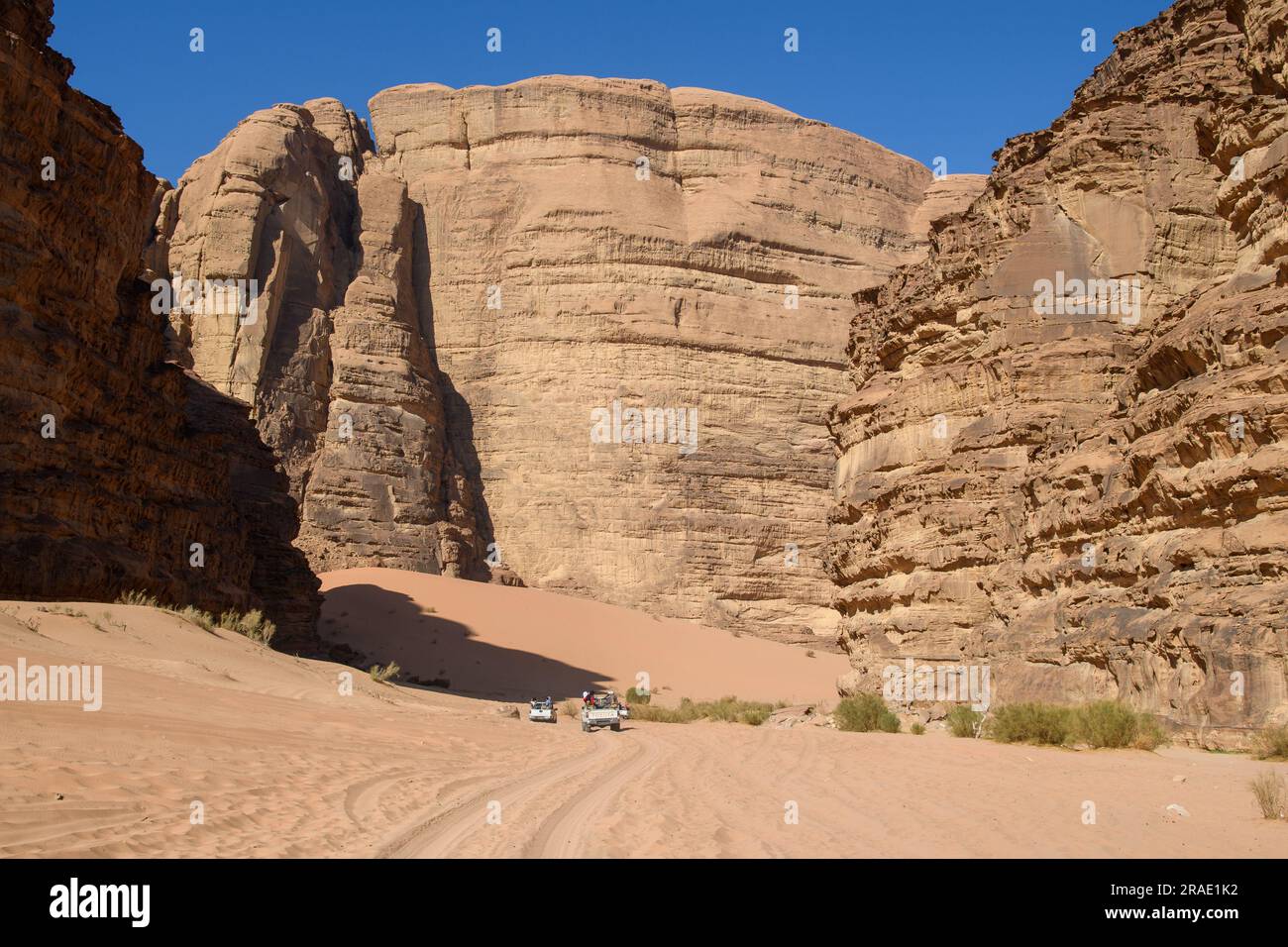 Wadi Rum, Jordanien - 19. Dezember 2022: Ein Konvoi aus Geländefahrzeugen mit Touristen fährt in Richtung Wadi Rum im jordanischen Teil der arabischen Wüste. Stockfoto