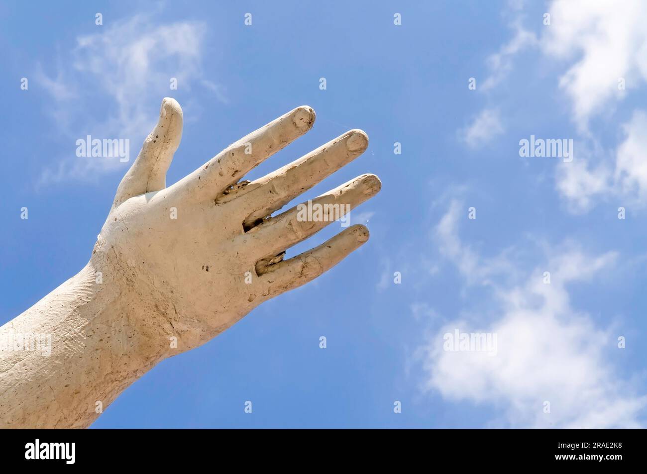 Eine Statue Hand zeigt den weißen Wolken am blauen Himmel als Idee der Freiheit Stockfoto