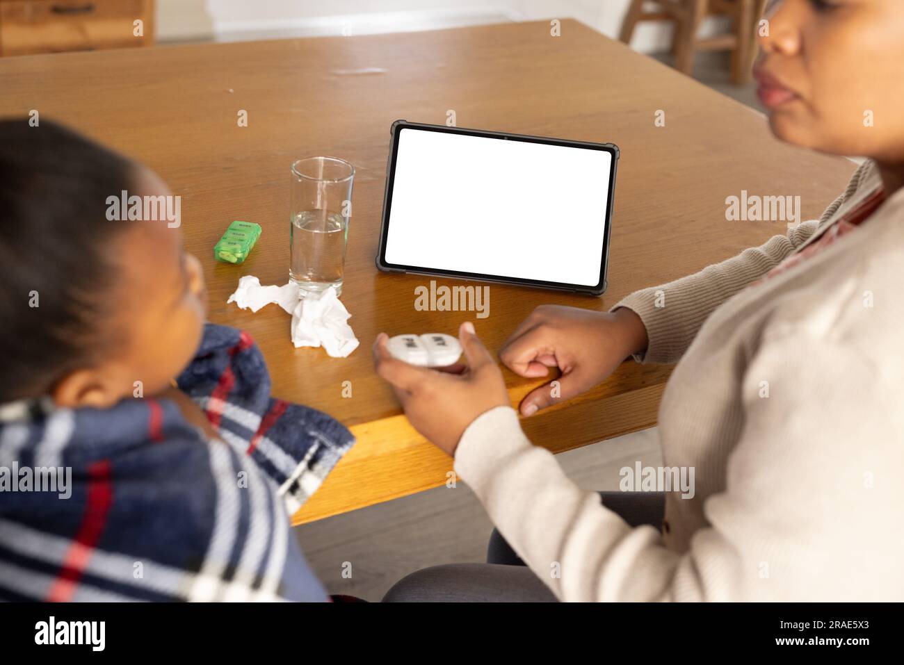 afroamerikanische Mutter und Tochter, die ein Tablet mit Kopierraum für die Online-medizinische Beratung verwenden Stockfoto