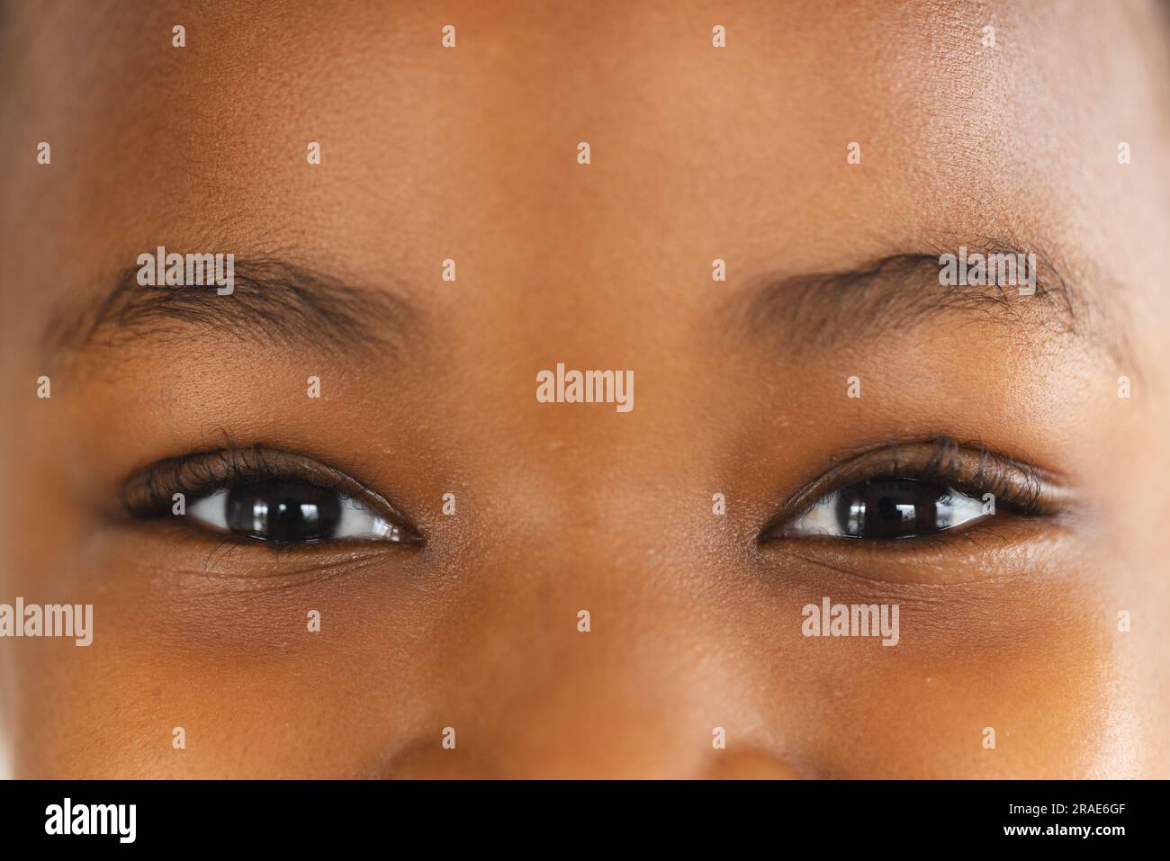 Nahaufnahme der Augen eines glücklichen afroamerikanischen Mädchens, das in die Kamera schaut Stockfoto