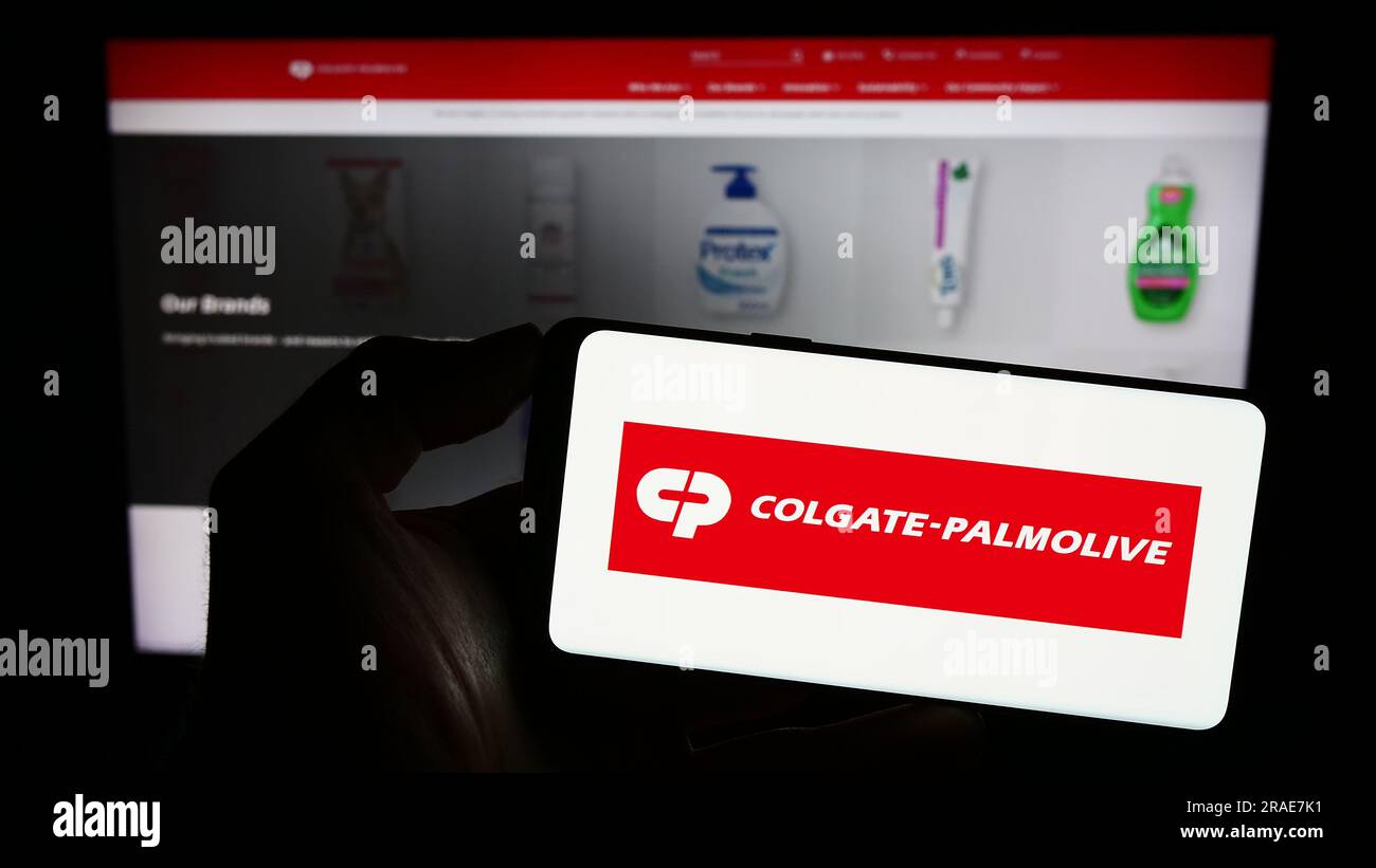 Person, die ein Smartphone mit dem Logo des Konsumgütergeschäfts Colgate-Palmolive Company auf dem Bildschirm vor der Website hält. Konzentrieren Sie sich auf das Display des Telefons. Stockfoto