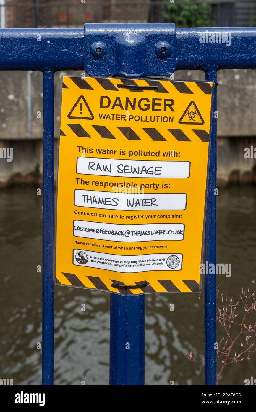 Protestschild lesen Gefahr Wasserverschmutzung, dieses Wasser ist mit rohem Abwasser verschmutzt. Die verantwortliche Partei ist Themse Wasser. River Wey, Guildford, Großbritannien Stockfoto