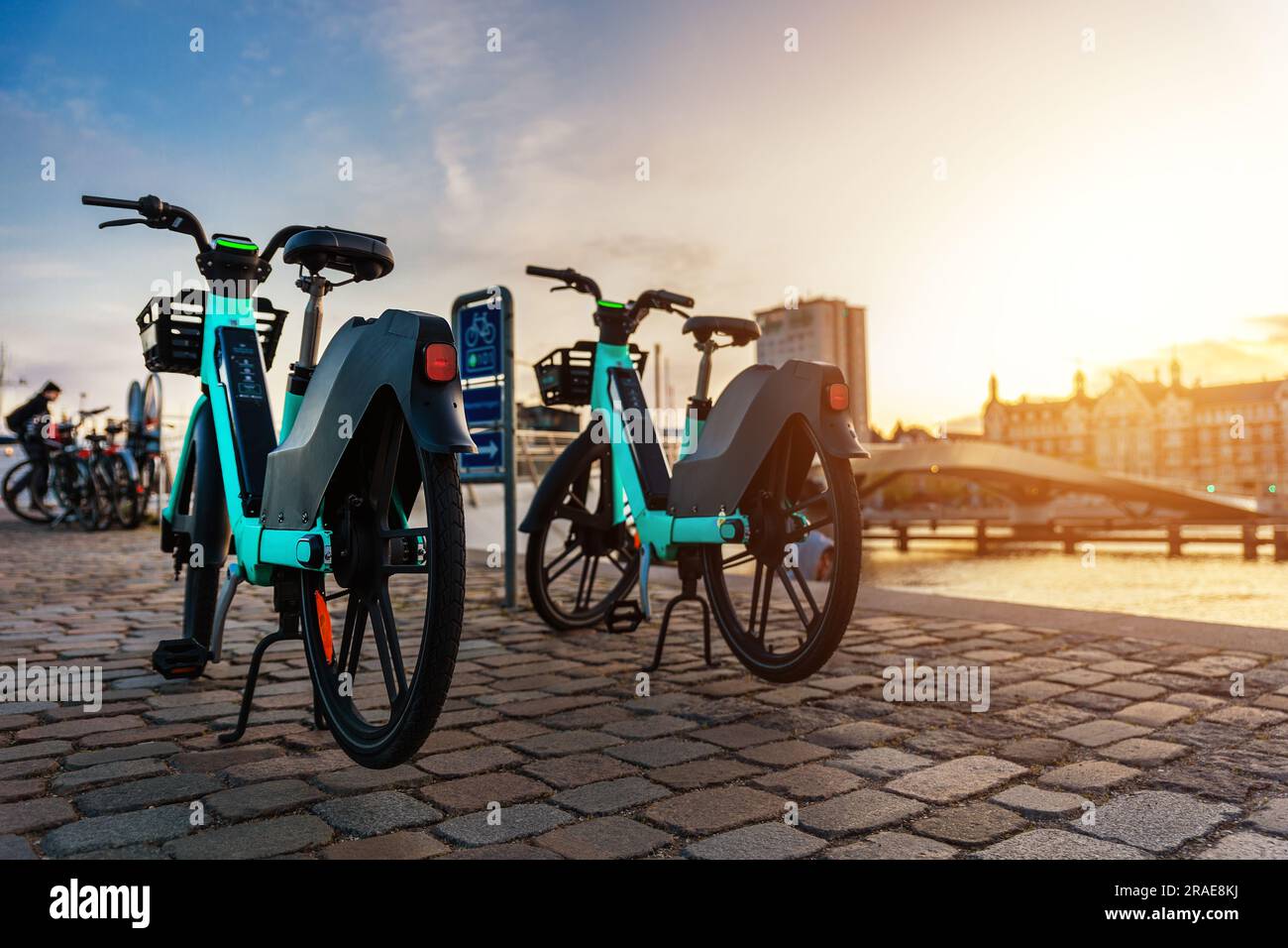 Malerische Aussicht Elektrische Leihfahrräder in der Nähe der modernen Fußgängerzone Lille Langebro Brücke Kopenhagen Halten Sie einen warmen Sonnenuntergang auf der Stadtstraße Stockfoto