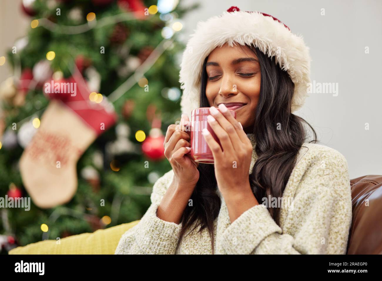 Weihnachten, Lächeln oder glückliche Frau mit Kaffee zu Hause in der Ferien- oder Ferienzeit mit einem warmen Getränk. Kalter Winter, Eierpunsch oder gemütliches Indianermädchen Stockfoto