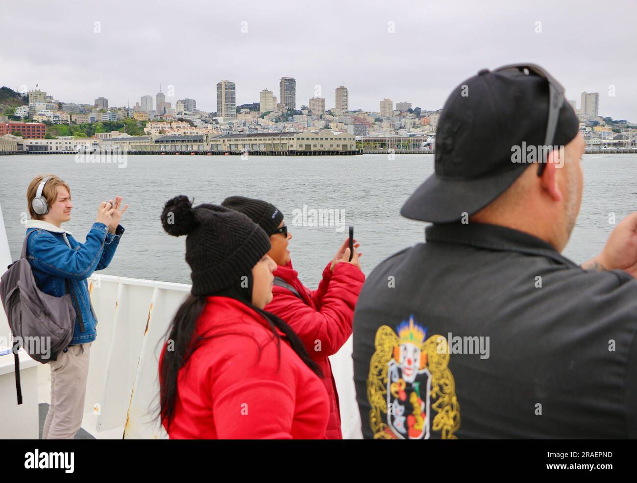 Touristen, die Handys benutzen, um Fotos zu machen, die sich Alcatraz an Bord einer Alcatraz City Cruises mit dem Hornblower Touristenboot San Francisco Kalifornien USA nähern Stockfoto