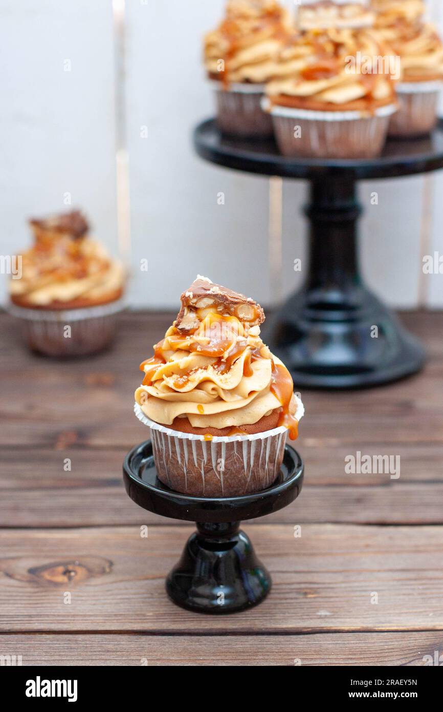 Erdnussbutter-Cupcakes mit gesalzenem Karamell, Toffee und Schokoladenbissen Stockfoto