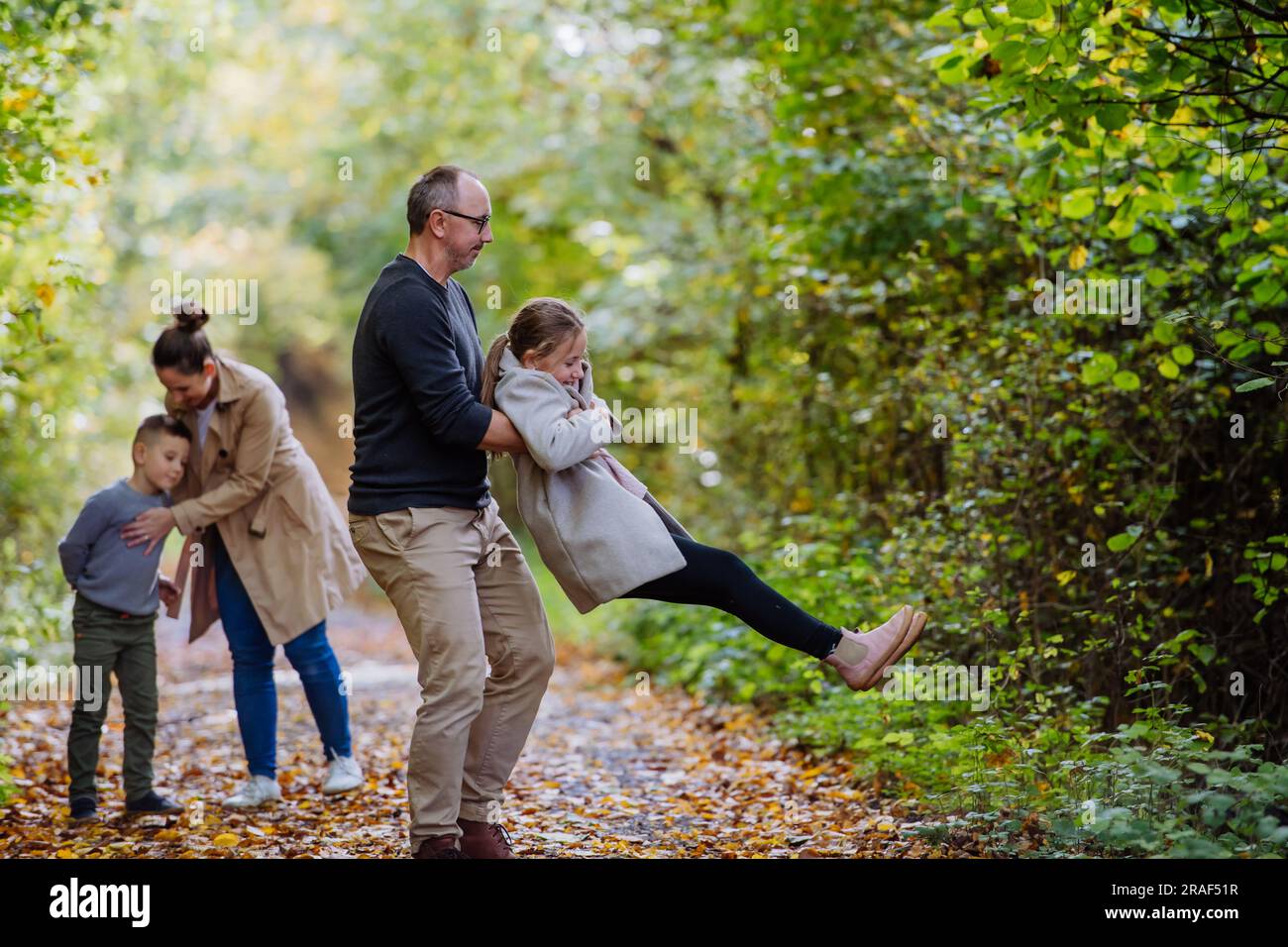 Glückliche Familie, die Spaß mit Kindern im Wald hat. Stockfoto