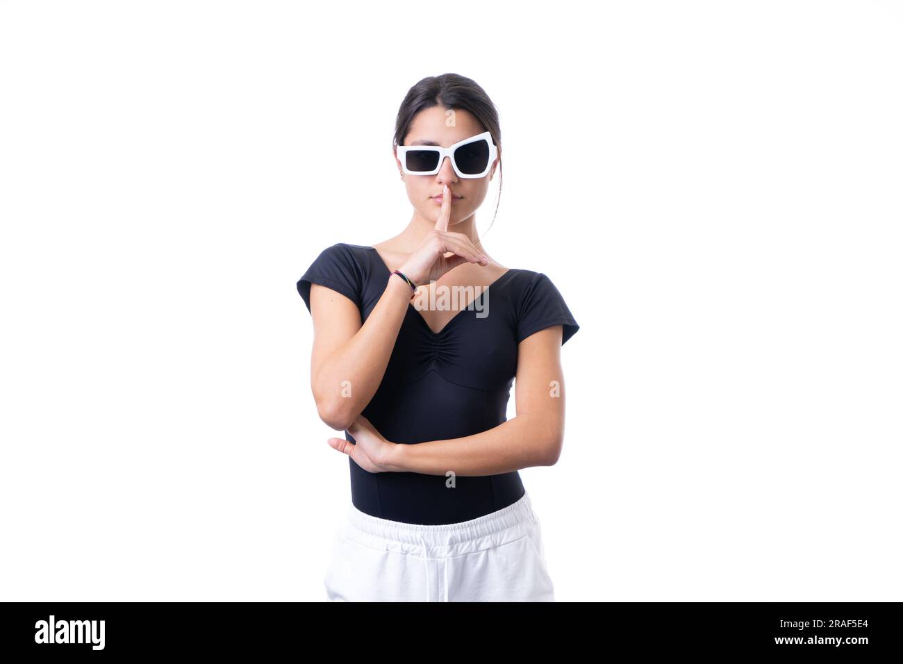 Studioporträt einer jungen braunen Modelin, die eine lustige, schicke weiße Sonnenbrille trägt. Stille Stockfoto