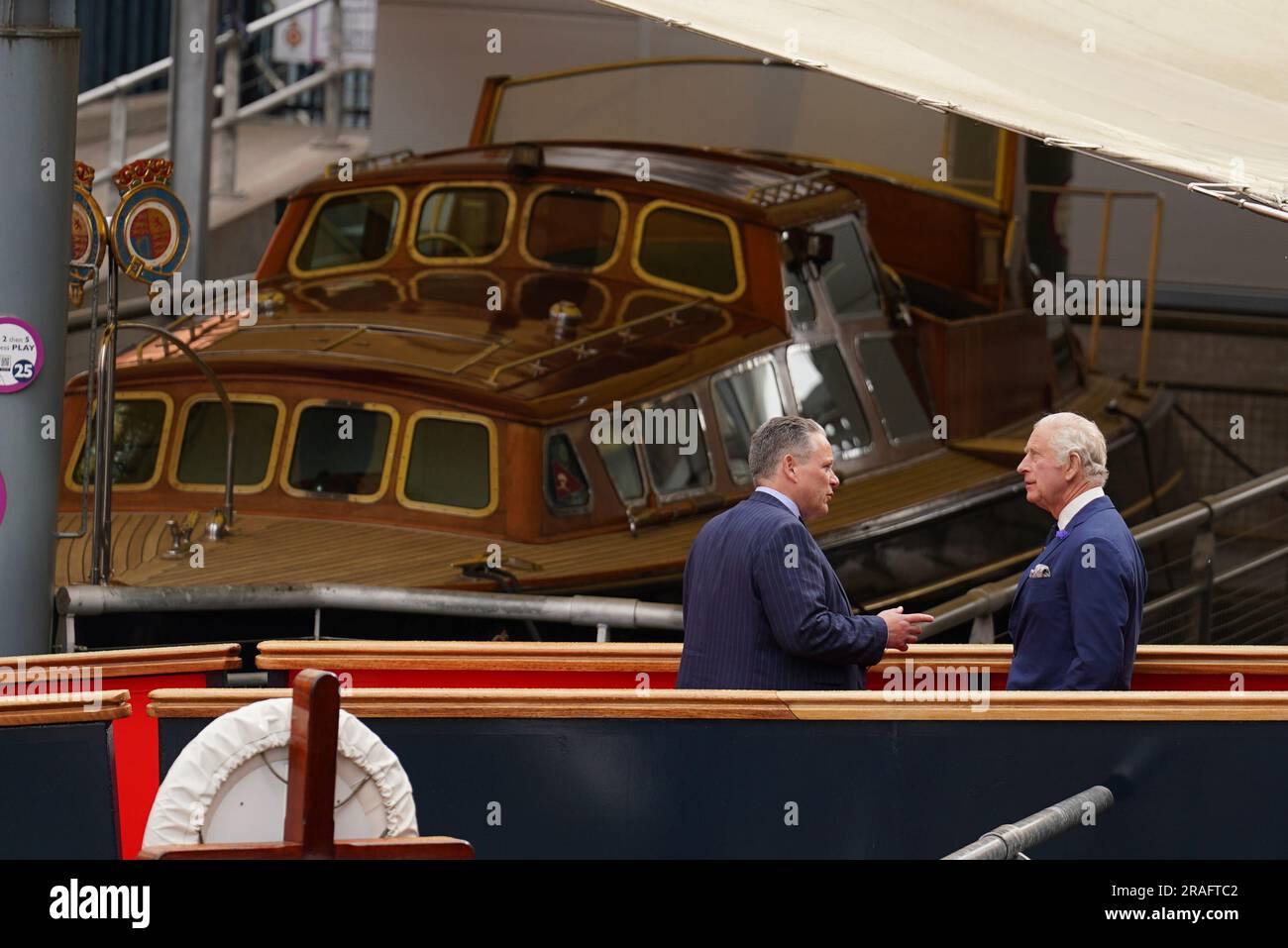 Bob Downie, Chief Executive der Royal Yacht Britannia (links), spricht mit König Karl III. Während einer Tour der Yacht, um 25 Jahre seit ihrer Ankunft in Edinburgh zu feiern, als Teil der ersten Holyrood Woche seit seiner Krönung. Foto: Montag, 3. Juli 2023. Stockfoto