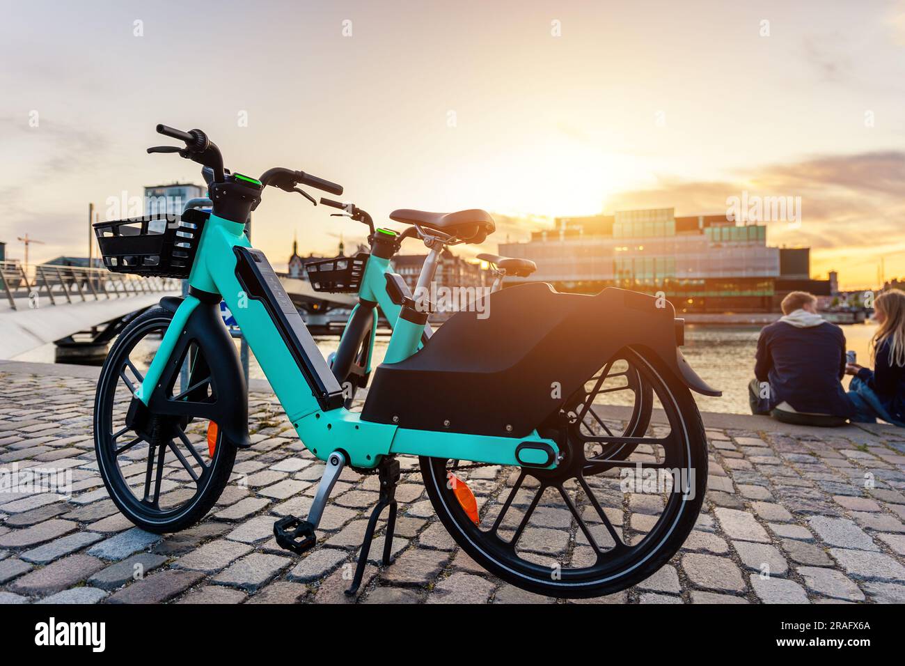 Malerische Aussicht Elektrische Leihfahrräder in der Nähe der modernen Fußgängerzone Lille Langebro Brücke Kopenhagen Halten Sie einen warmen Sonnenuntergang auf der Stadtstraße Stockfoto