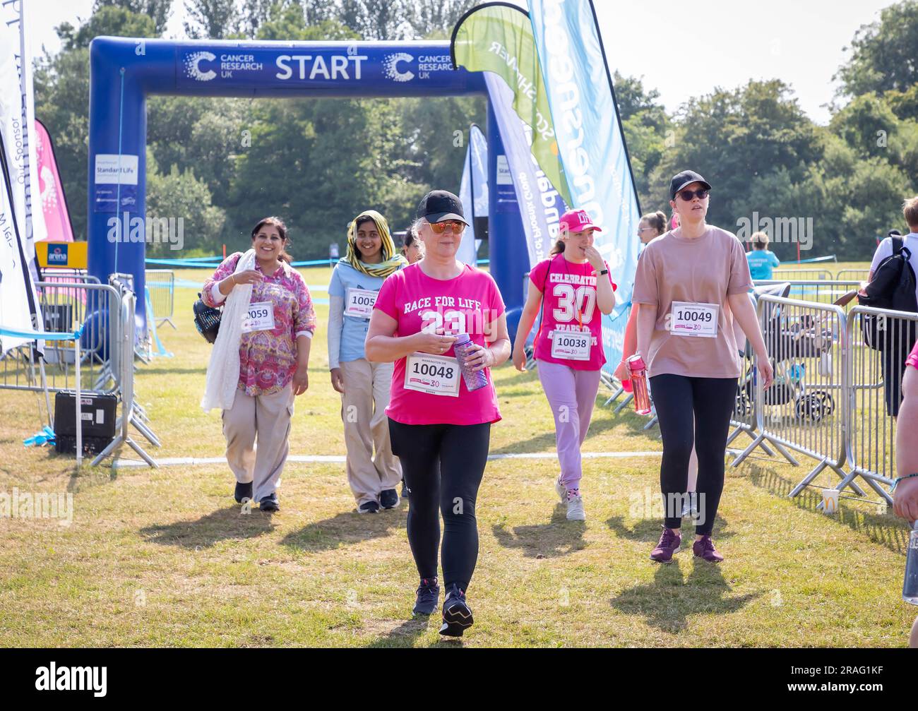 Race for Life in Aid of Cancer Research. Hunderte von Leuten in Rosa. Der Start des 10k-km-Laufs, aber einige liefen zu Fuß Stockfoto