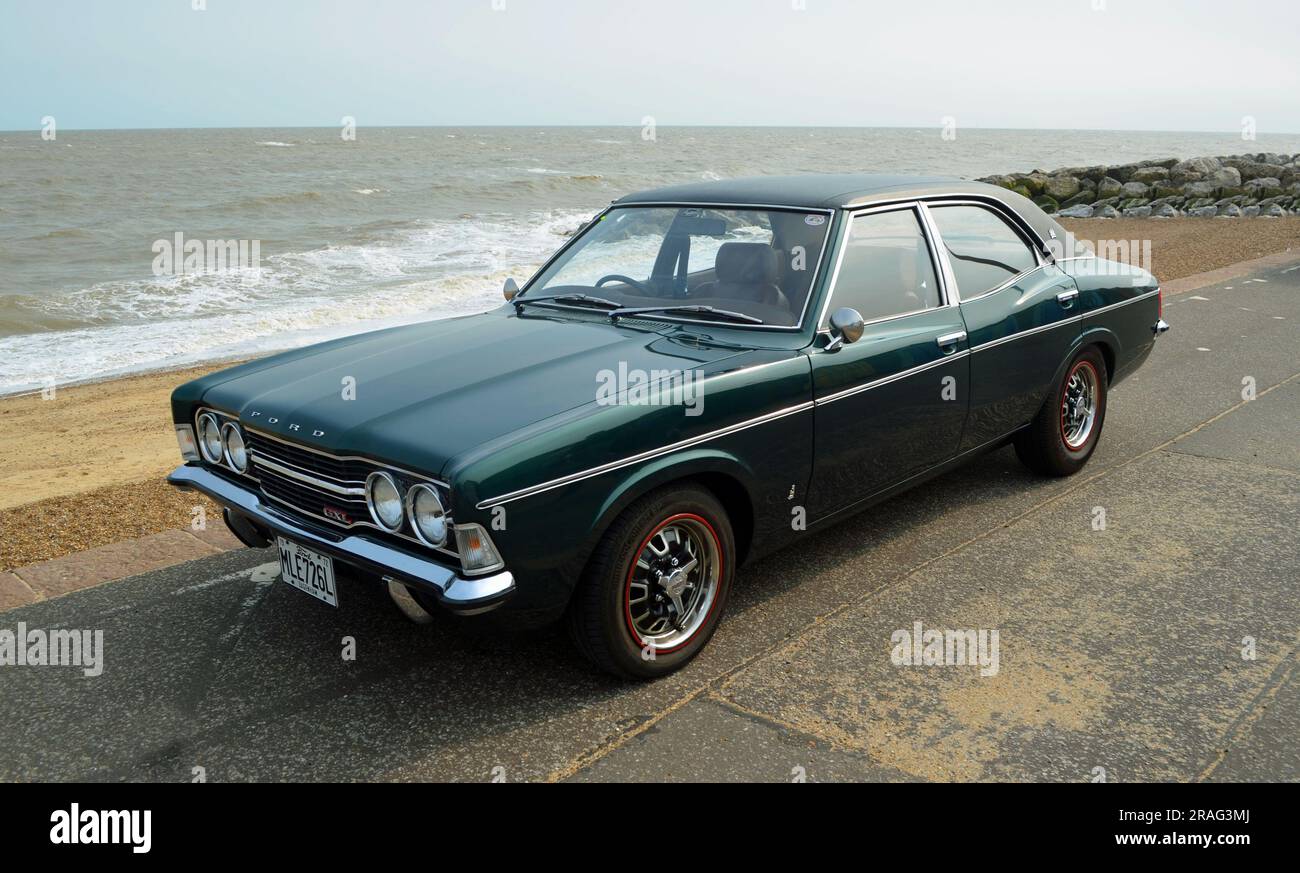 Der klassische Ford Cortina Mark 3 parkt an der Strandpromenade und am Meer im Hintergrund. Stockfoto