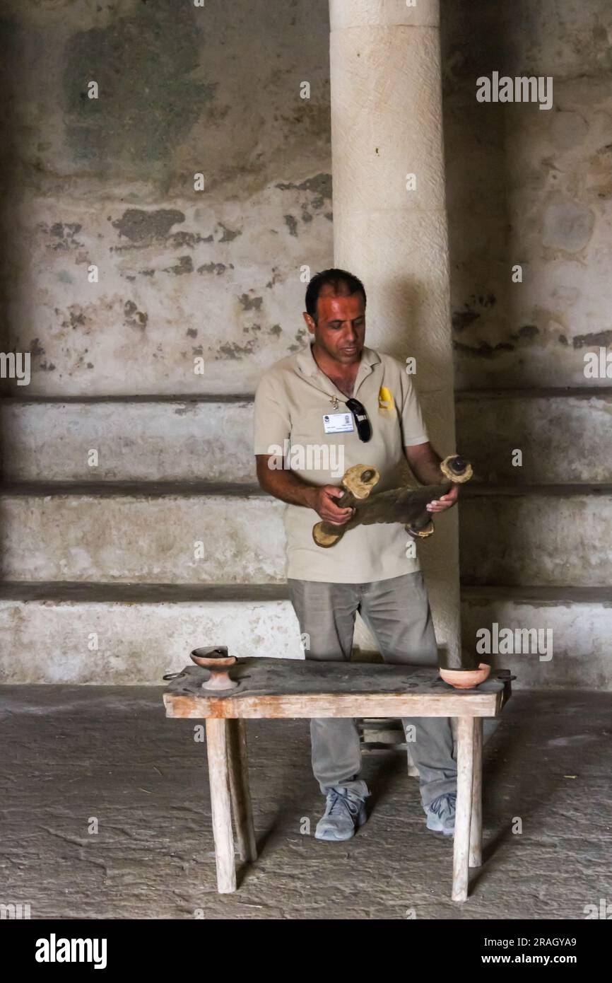 Ein Reiseleiter zeigt, wie eine Schriftrolle in einer Synagoge im Freiluftmuseum Nazareth Village in Nazareth, Israel, gelesen werden kann. Stockfoto