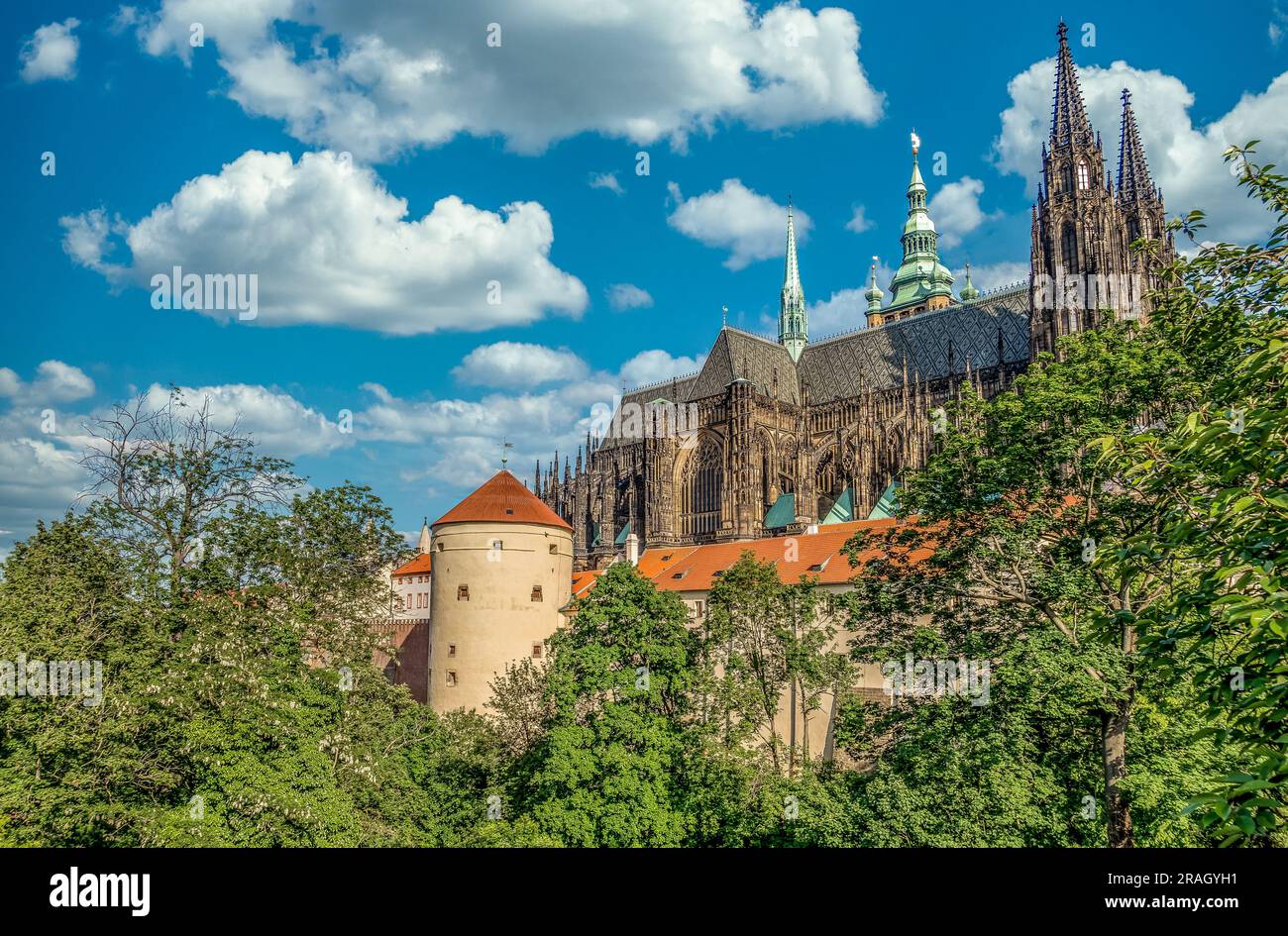 Blick auf St. Vitus-Dom und Staatskasse, kreisförmiger Waffenturm des Abwehrsystems der Prager Burg mit wolkenblauem Himmel Stockfoto