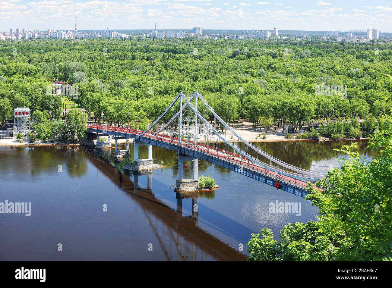 Luftfoto, Fußgängerbrücke über den Fluss Dnipro in Sommerlandschaft, die den zentralen Teil Kiews mit der Insel Truchanow verbindet. Stockfoto