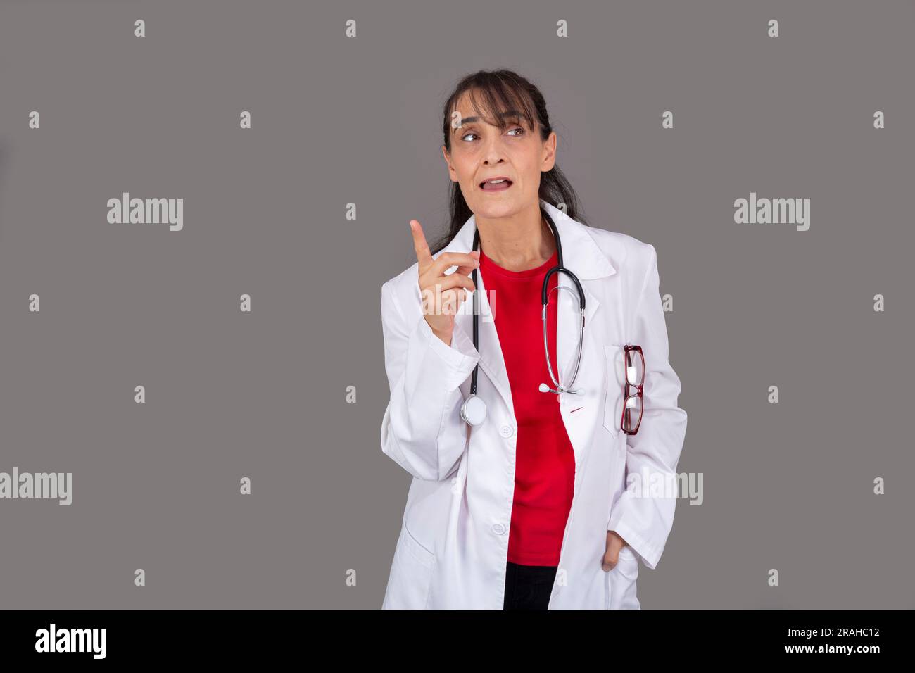 Ärztin mit durchdachtem Gesichtsausdruck isoliert vom Hintergrund Stockfoto