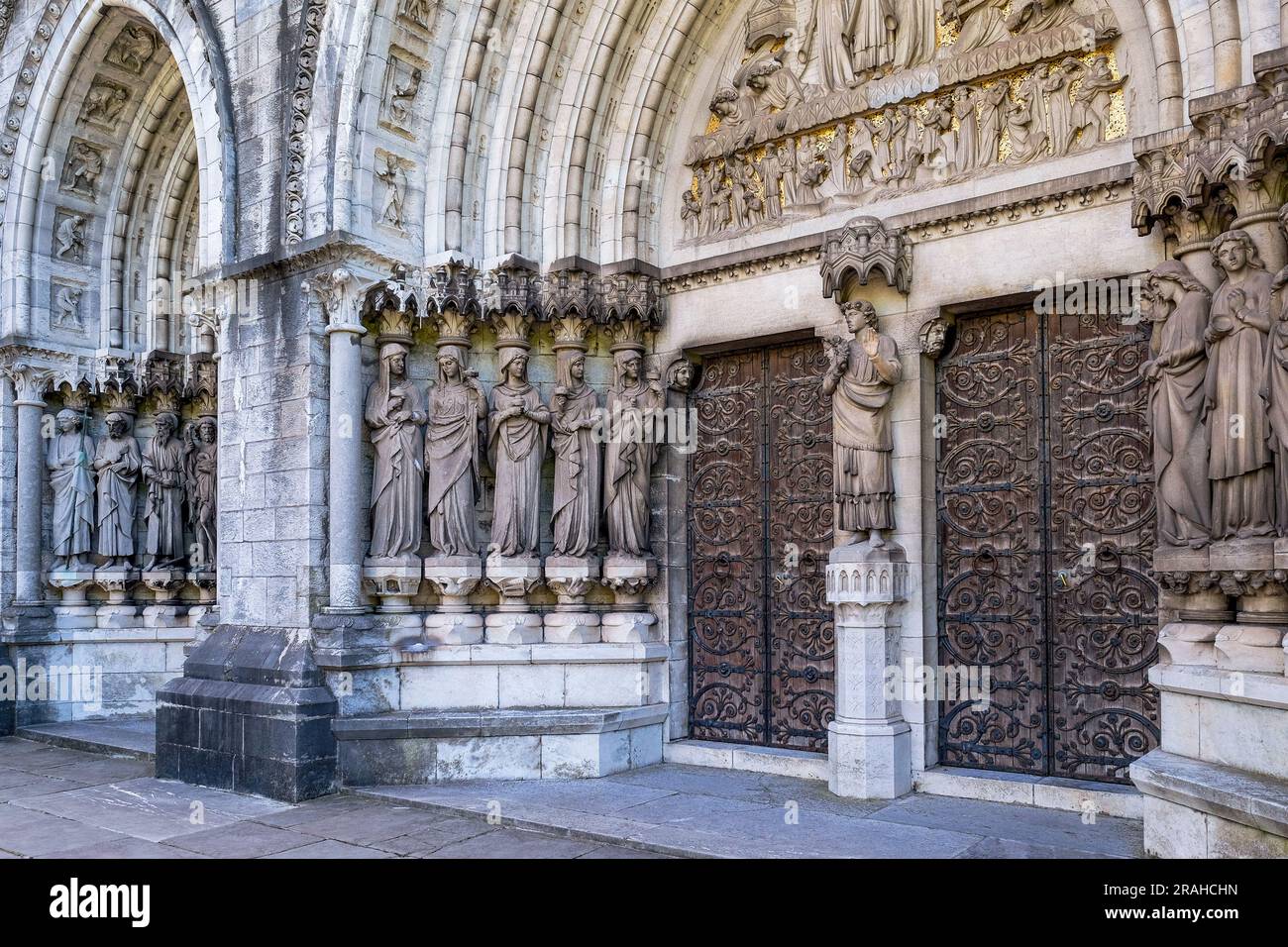 Eingang zur Kathedrale von Saint Fin Barre. Kunstvolle und detailgetreue Skulpturen umgeben die großen Holztüren. Cork, Irland. Stockfoto