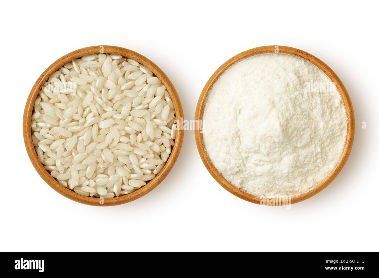 Körner und Mehl von Reis in einer Holzschüssel auf weißem Hintergrund Stockfoto