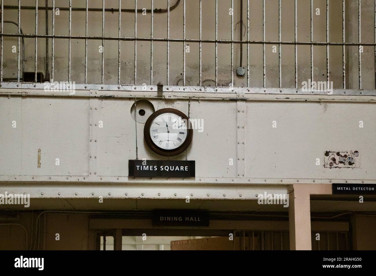 Uhr über dem Times Square Schild neben einem Metalldetektor am Eingang zum Speisesaal Alcatraz Gefängnis San Francisco Kalifornien USA Stockfoto