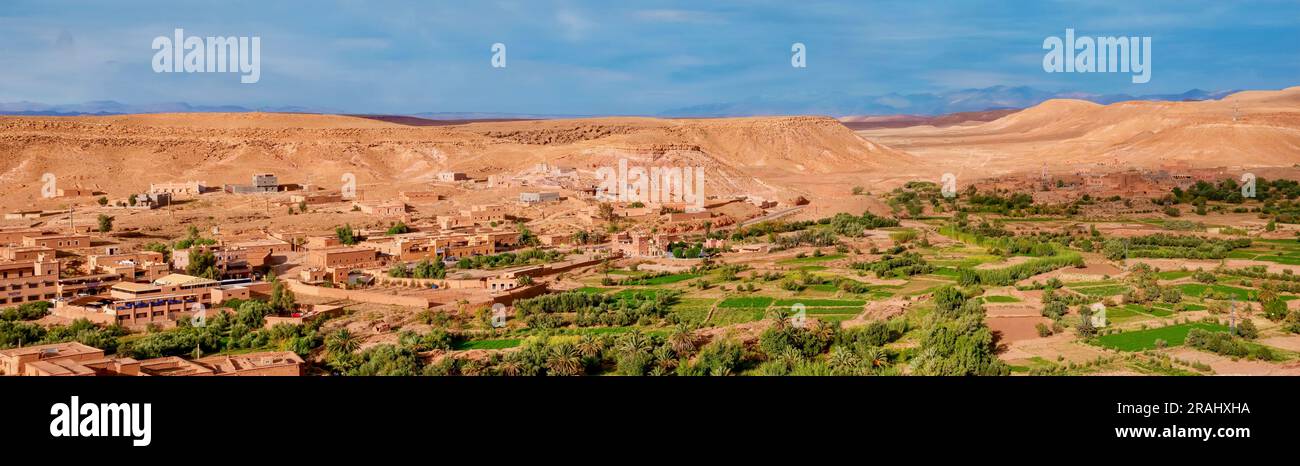 Das üppige fruchtbare Ackerland des Draa-Tals ist umgeben von neuer Stadtentwicklung und der trockenen Bergregion Jebel Sarho im Süden Marokkos. Stockfoto