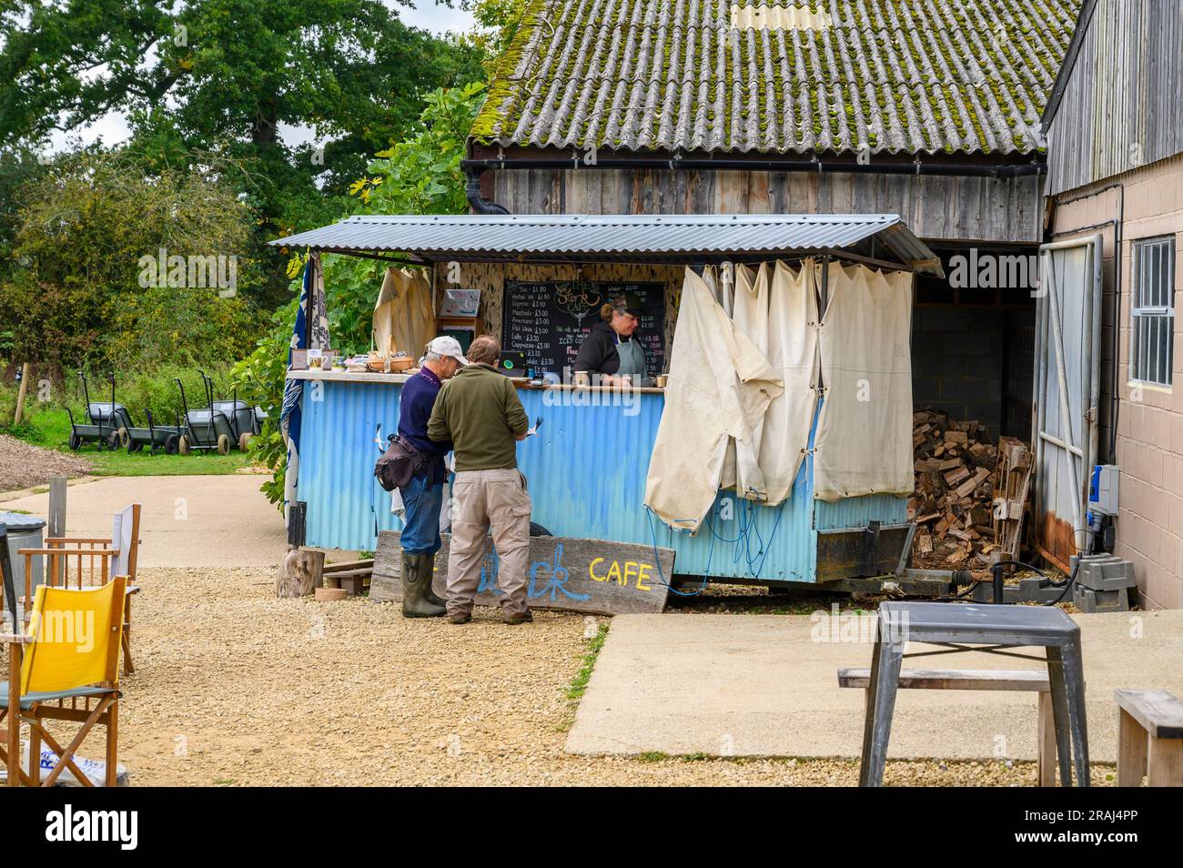 Zwei Besucher werden im rustikalen Stork Café in Knepp Wildland des Knepp Estate in West Sussex, England, serviert. Stockfoto