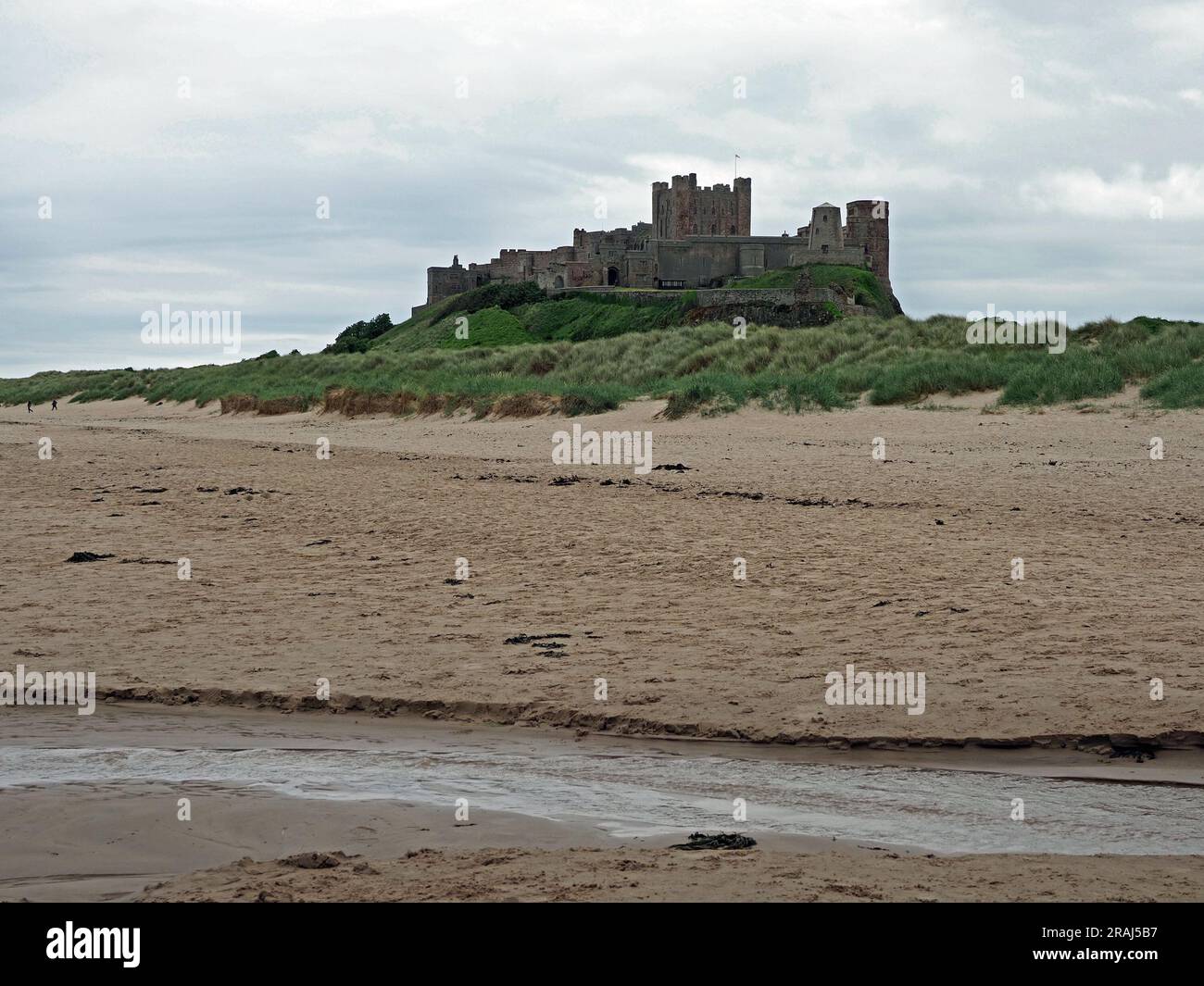 Mächtige Festung von Bamburgh Castle überragt den Nordseestrand und die Sanddünen Northumbria, England, Großbritannien Stockfoto