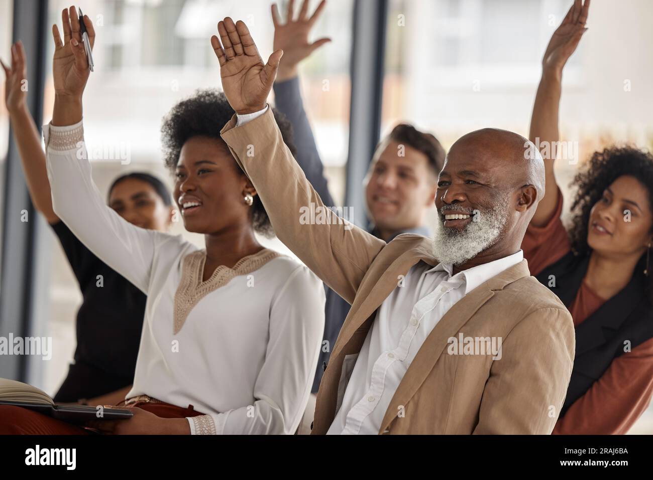 Zufriedene Geschäftsleute, Workshop oder Hände hoch für die Teilnahme an Seminaren zum Erlernen von Fähigkeiten im Büro. Wählen Sie, Männer oder Frauen im Publikum zusammen für Stockfoto