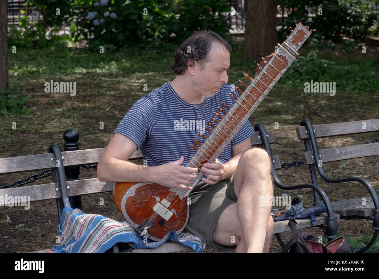 Ein Mann spielt die Sitar im Washington Square Park in Greenwich Village, Manhattan, New York City, Sommer 2023. Stockfoto