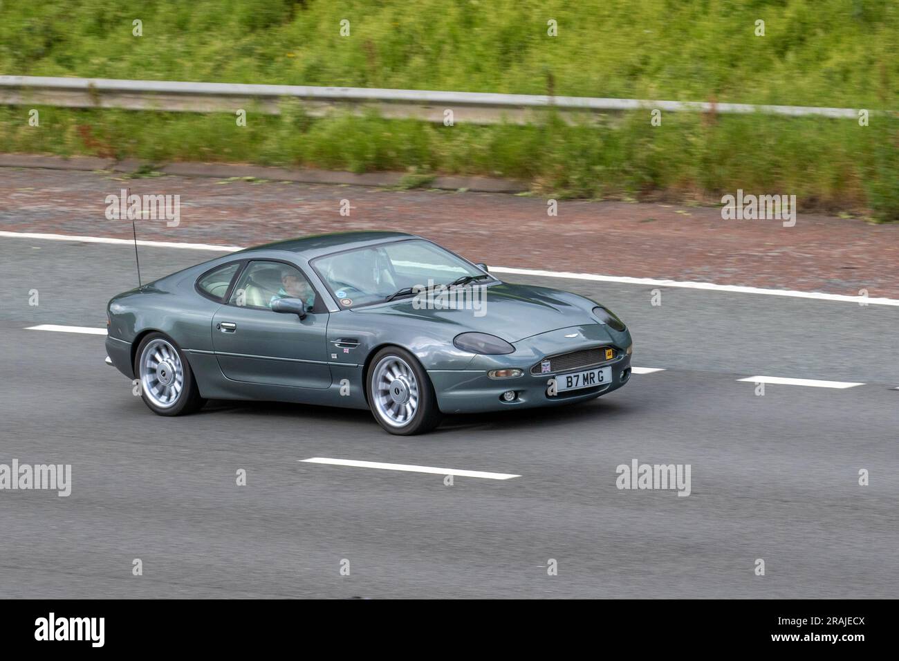 1995 90s Neunziger Aston Martin FH V6 Grey Car Coupe Benzinmotor 3239 cm3; Fahrt mit hoher Geschwindigkeit auf der Autobahn M6 in Greater Manchester, Großbritannien Stockfoto