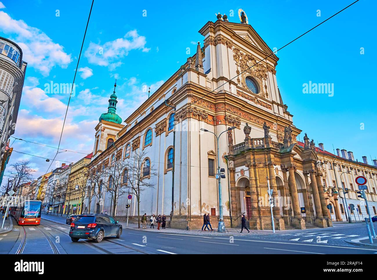 Die reich verzierte Kirche St. Ignatius von Loyola und die moderne Straßenbahn auf der Jecna Straße, Prag, Tschechien Stockfoto