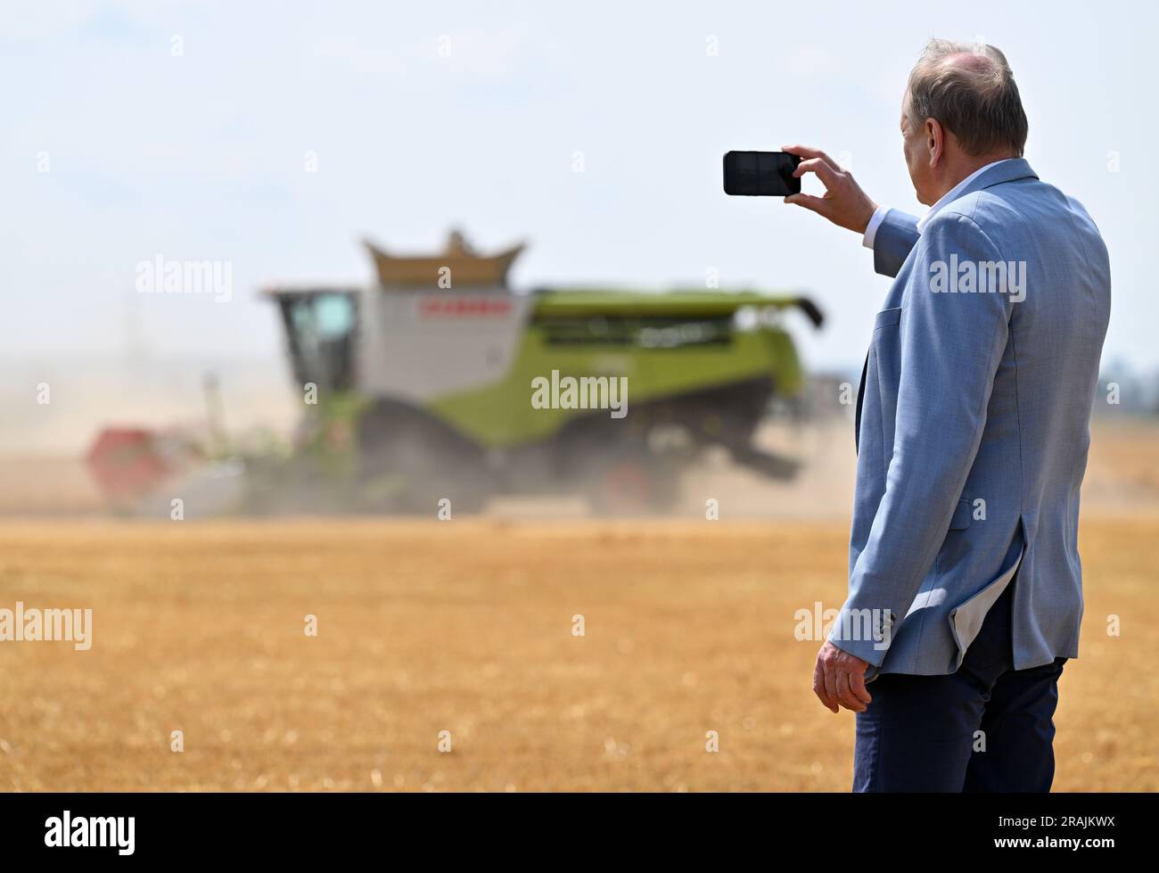 Riethnordhausen, Deutschland. 04. Juli 2023. Joachim Rukwied, Präsident des Deutschen Bauernverbandes, macht ein Foto der Wintergerstenernte auf einem Feld der Universal Agrar GmbH. Der Deutsche Bauernverband gibt eine erste Prognose für die diesjährige Ernte vor. In einigen Teilen Deutschlands, einschließlich des fruchtbaren Thüringer Beckens, beginnt die Getreideernte heute. Kredit: Martin Schutt/dpa/Alamy Live News Stockfoto