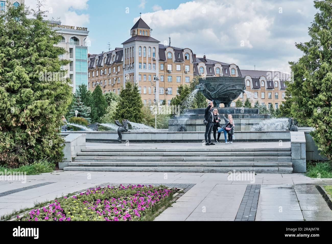 Kasan, Russland - Juni 8. 2023: Platz mit einem Brunnen in Form einer Schüssel - Kessel im Millennium Park. Die Familie macht ein Selfie vor dem La Stockfoto