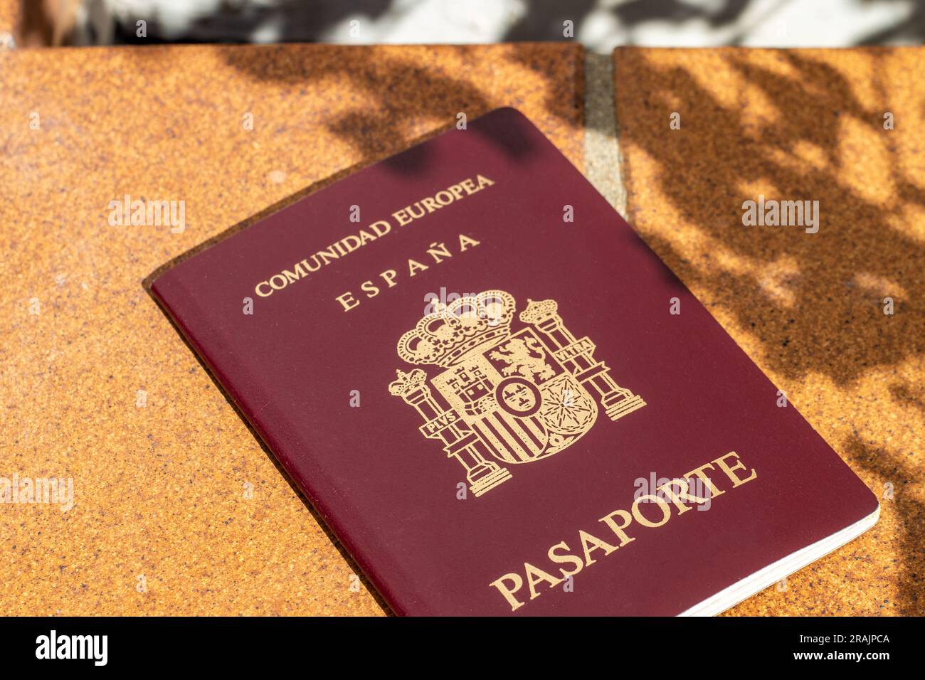 Pass der Europäischen Union, Spaniens, mit einer Hand gehalten, und man kann eine Sonnenbrille sehen Stockfoto