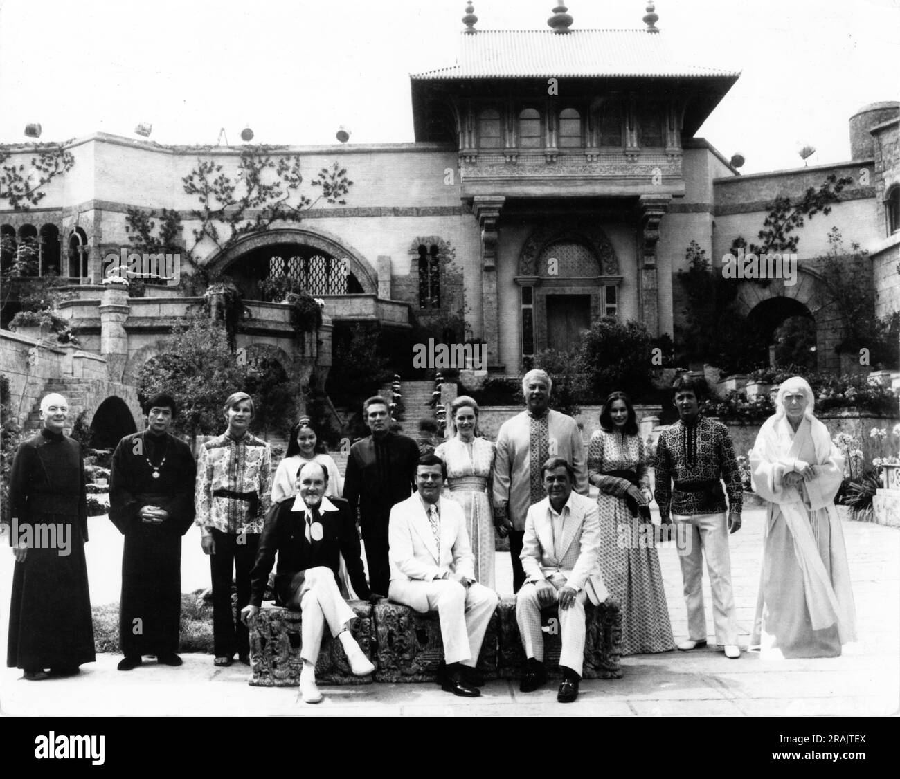 JOHN GIELGUD JAMES SHIGETA MICHAEL YORK OLIVIA HUSSEY PETER FINCH LIV ULLMANN GEORGE KENNEDY SALLY KELLERMAN BOBBY VAN UND CHARLES BOYER mit Charles JARROTT Producer ROSS HUNTER und seinem Lebenspartner und Associate Producer JACQUE MAPES Und Crew-Gruppenporträt auf dem Shangri La-Set während der Dreharbeiten des VERLORENEN HORIZON 1973-Regisseurs CHARLES JARROTT Roman James Hilton Drehbuch Larry Kramer Kostümdesigner Jean Louis Musik Burt Bacharach Lieder geschrieben von Burt Bacharach und Hal David A. Roos Hunter Production/Columbia Pictures Stockfoto