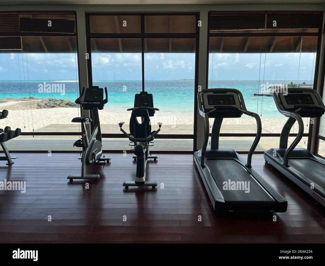 Fitnessstudio mit schönem Blick auf den Strand und türkisfarbenem Wasser in einem Luxusresort. Stockfoto