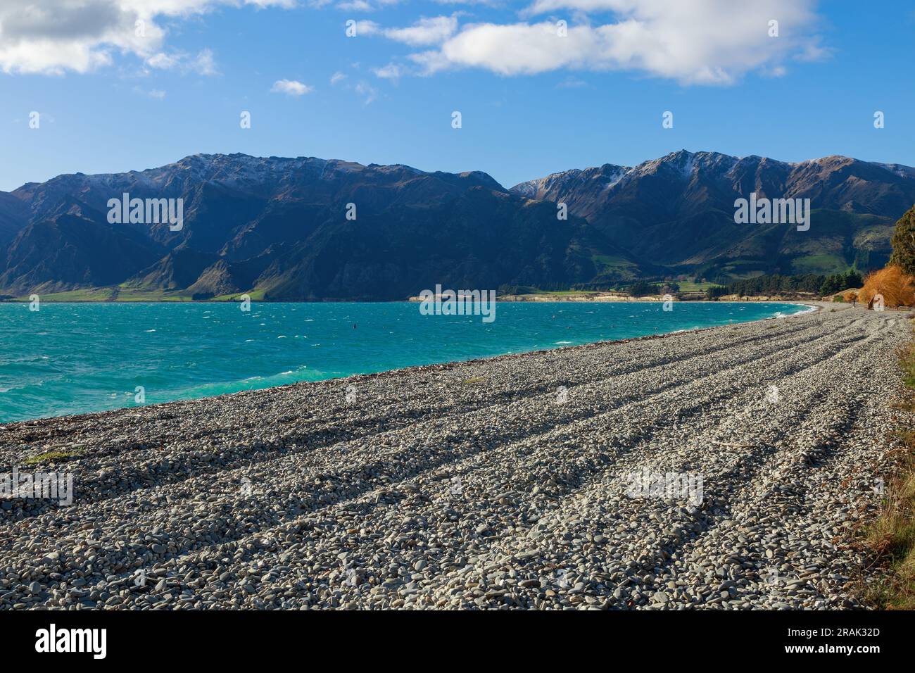 Ein steiniger Strand am Ufer des wunderschönen Lake Hawea auf der Südinsel Neuseelands Stockfoto