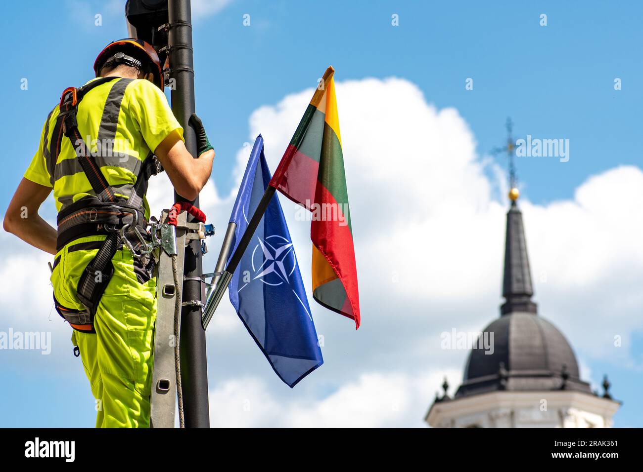 Installation von Überwachungs- und Sicherheitskameras mit Flaggen der NATO und Litauens vor dem NATO-Gipfel 2023 im Zentrum von Vilnius mit Turmglocke Stockfoto