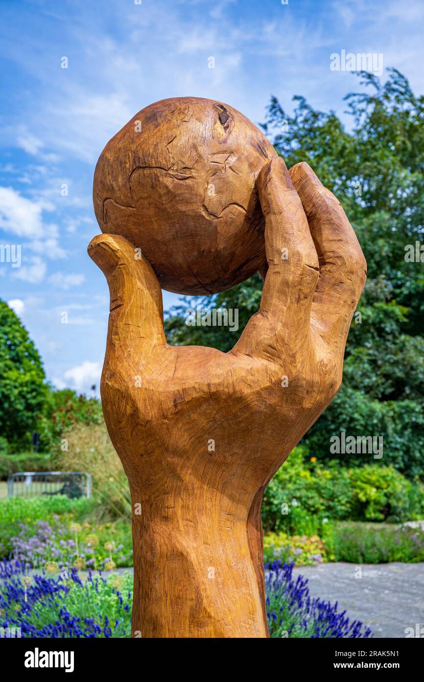 Grantham, Lincolnshire, Großbritannien. 4. Juli 2023 Eine kürzlich enthüllte Skulptur namens Isaac's Apple im Wyndham Park, Grantham, benannt nach Sir Isaac Newton, der vor Ort geboren wurde, besuchte die Kings School in der Stadt, bevor er nach Cambridge ging. Die Hand, die den Apfel hält, wurde aus einem einzigen Eichenholzwagen geschnitzt und ersetzt eine frühere ähnliche Skulptur. Kredit: Matt Limb OBE/Alamy Live News Stockfoto
