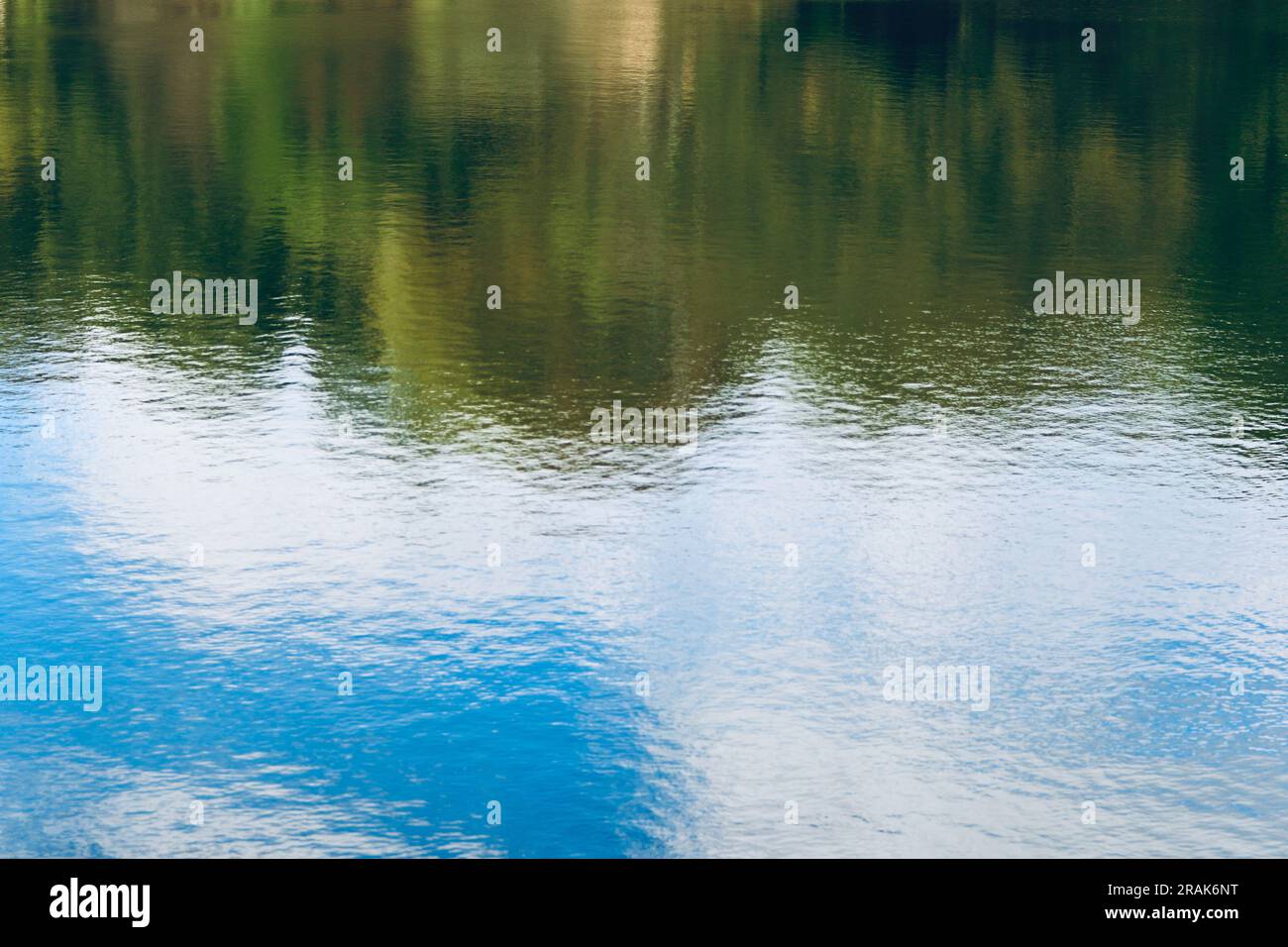 Bäume und blauer Himmel, der vom Wasser des Sees reflektiert Stockfoto