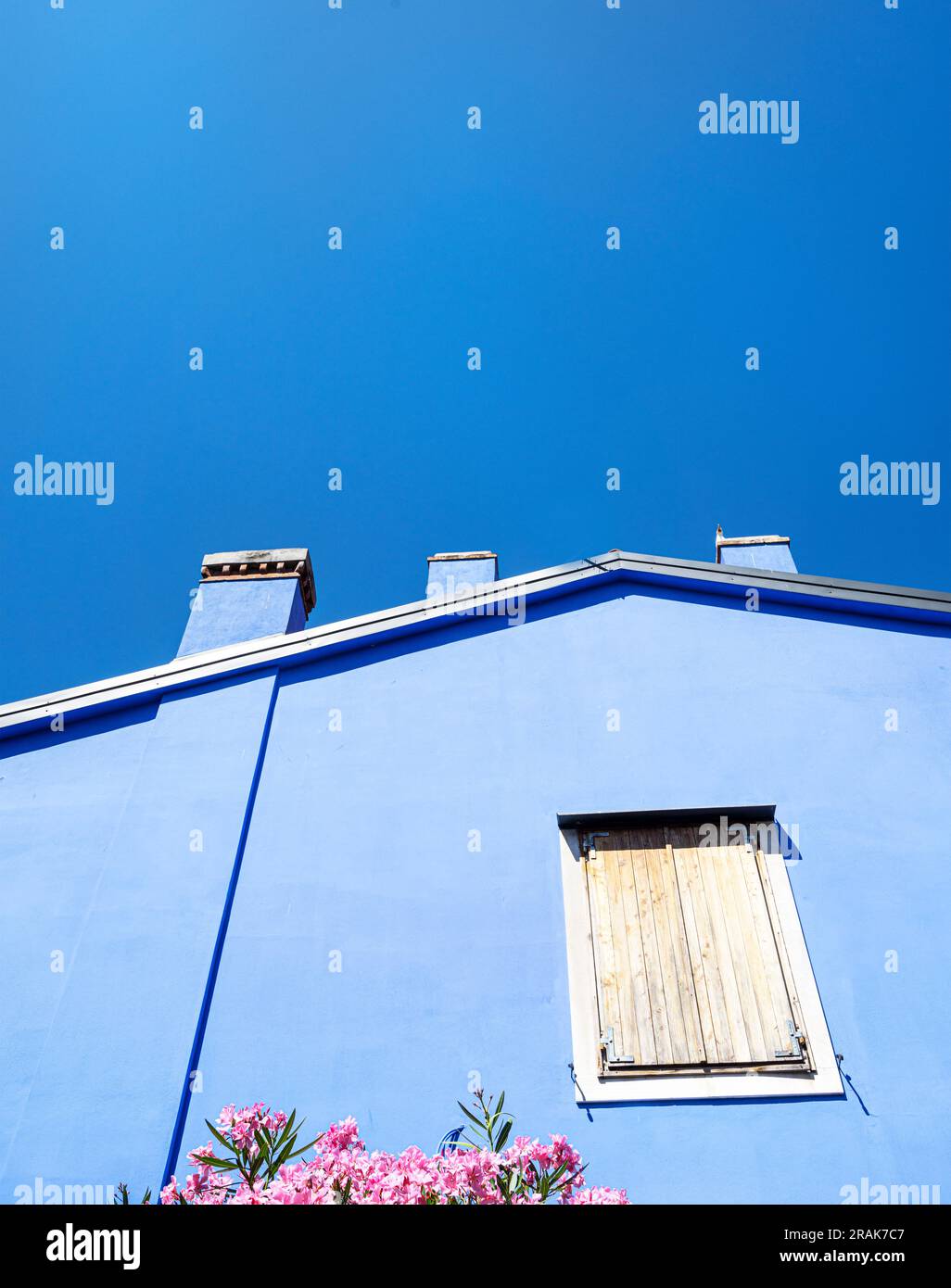Koper, Slowenien. 2. Juli 2023. Der blaue Himmel über einem blauen Haus im Stadtzentrum Stockfoto