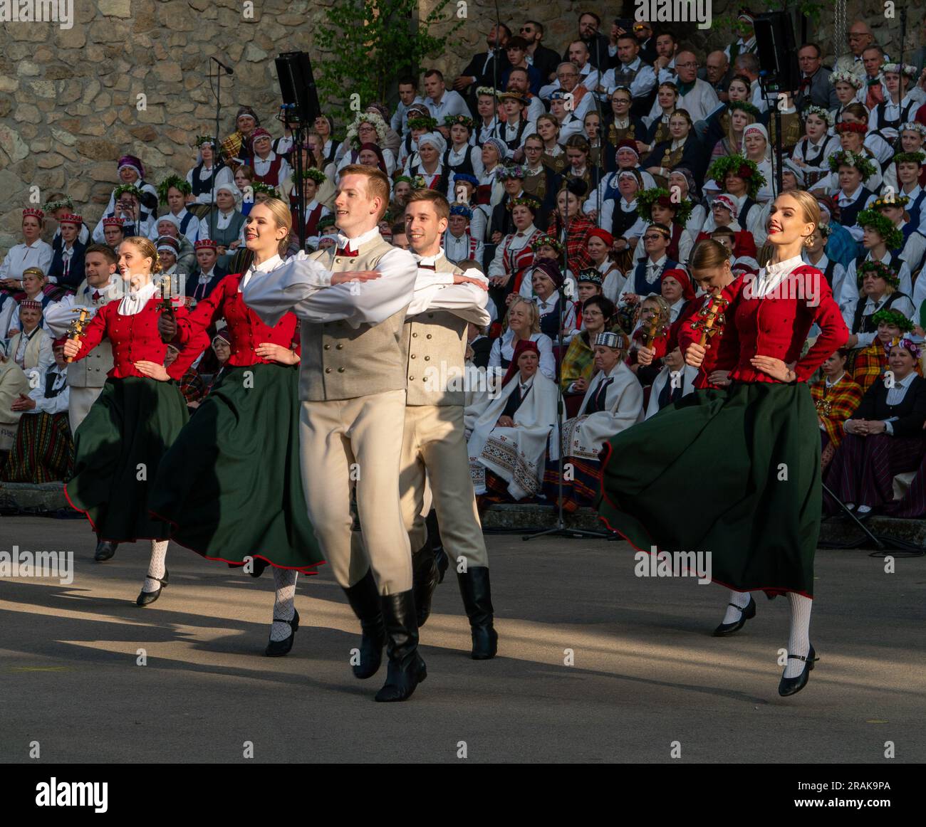 Dobele, Lettland - 27. Mai 2023. Lächelnde Volkstänzer in Tanzbewegung vor den Volkshorsängern während des XXVII Nationwide Lettischen Song und XV Stockfoto