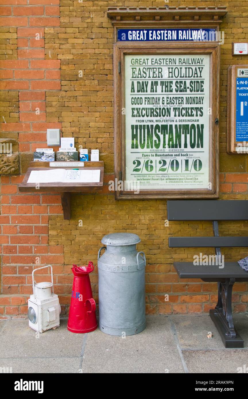 Ausstellung von Milk Churn, Lamp and Advertising Poster für die Great Eastern Railway AUF dem Bahnsteig am Royal Wolferton Station, Großbritannien Stockfoto