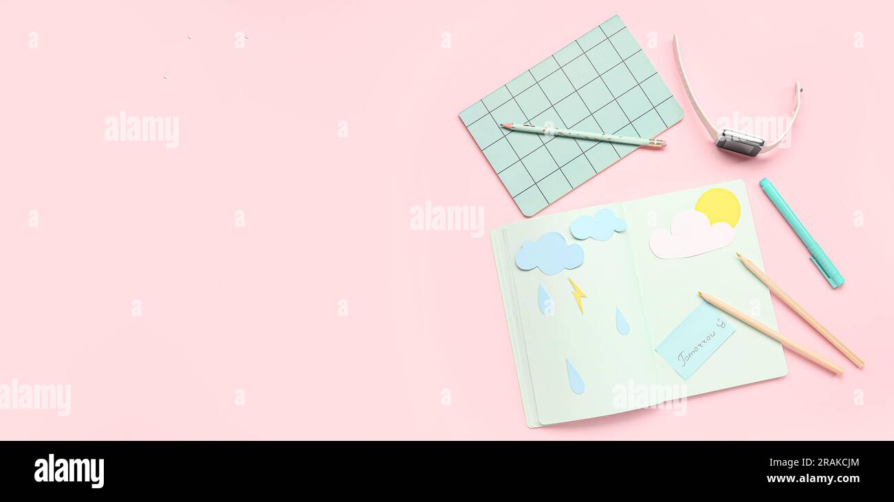 Notebooks mit Papierwolken, Regentropfen, Bleistiften und Smartwatch auf pinkfarbenem Hintergrund. Wettervorhersagekonzept Stockfoto