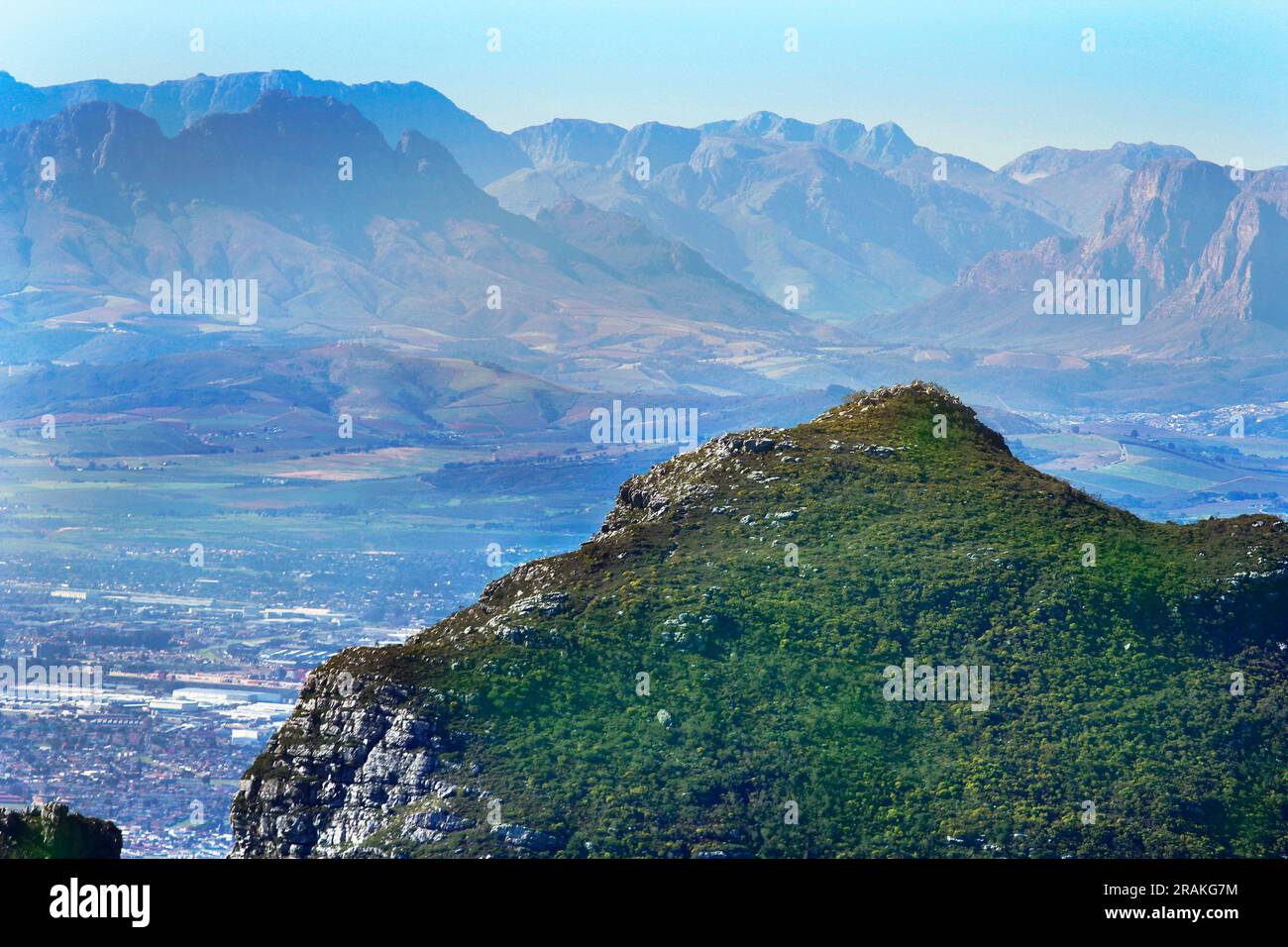 Die Aussicht vom Gipfel des Tafelbergs an einem schönen Wintertag. Auch Blick auf die Rückseite des Tafelbergs aus einem Park in Kapstadt. Stockfoto